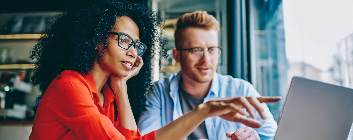 A woman and a man looking up information on a laptop