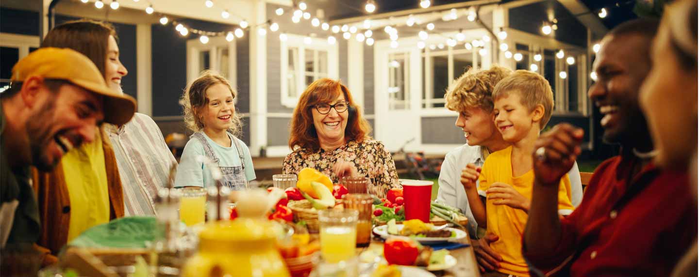 A group of family and friends enjoy an outdoor dinner